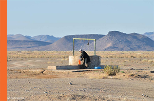 Man at remote well, filling water in a gallon